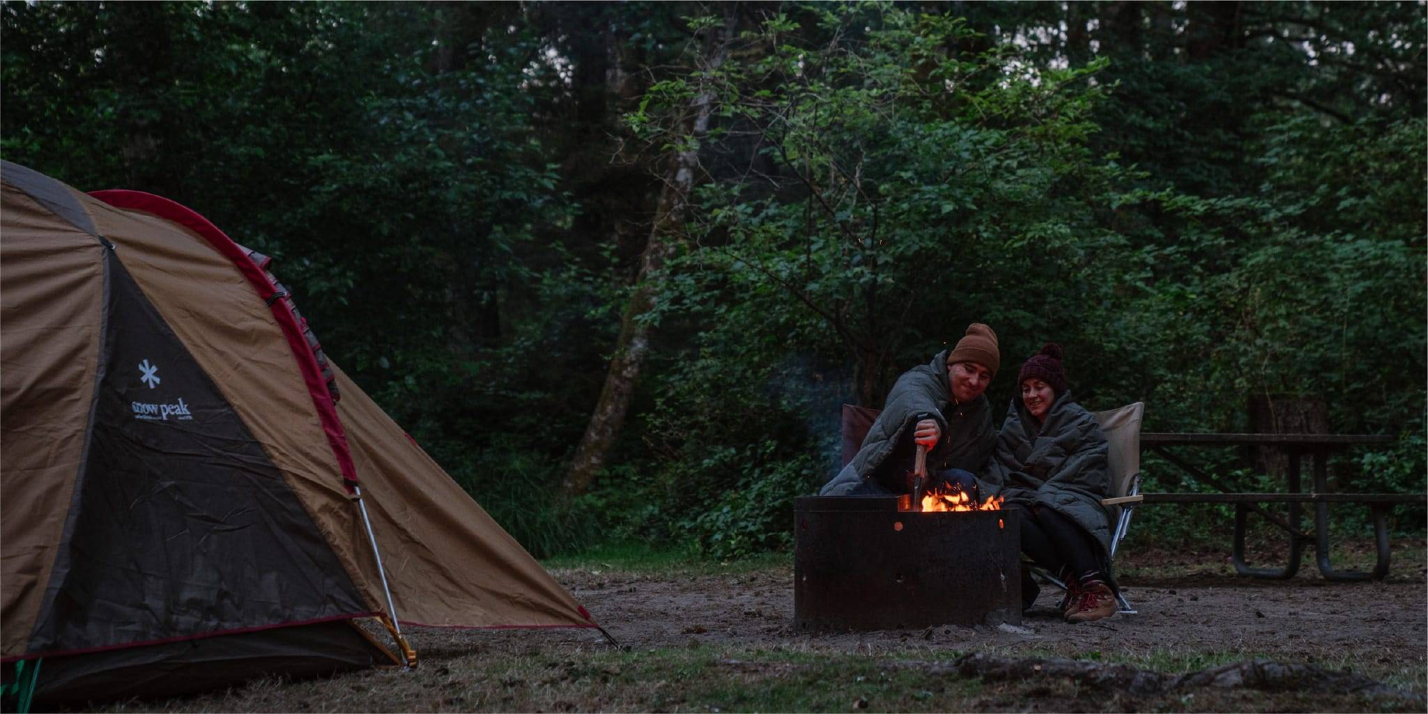 Couple camping with Snow Peak tent and bonfire