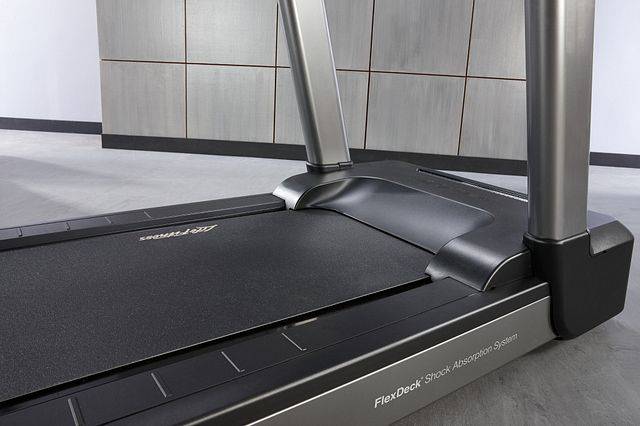 A treadmill is sitting on a concrete floor in a room - image