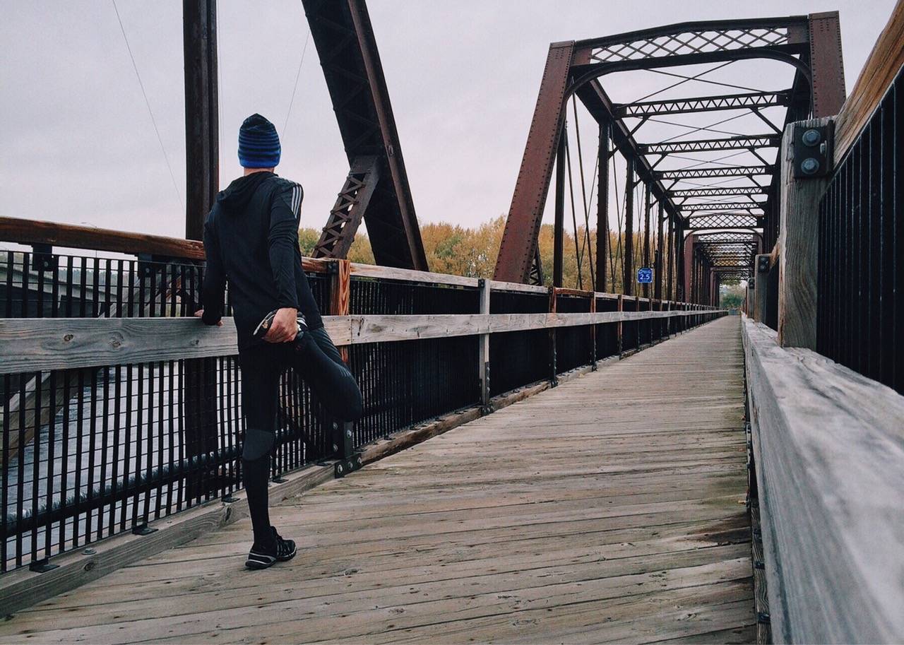 Man Stretching On A Bridge 