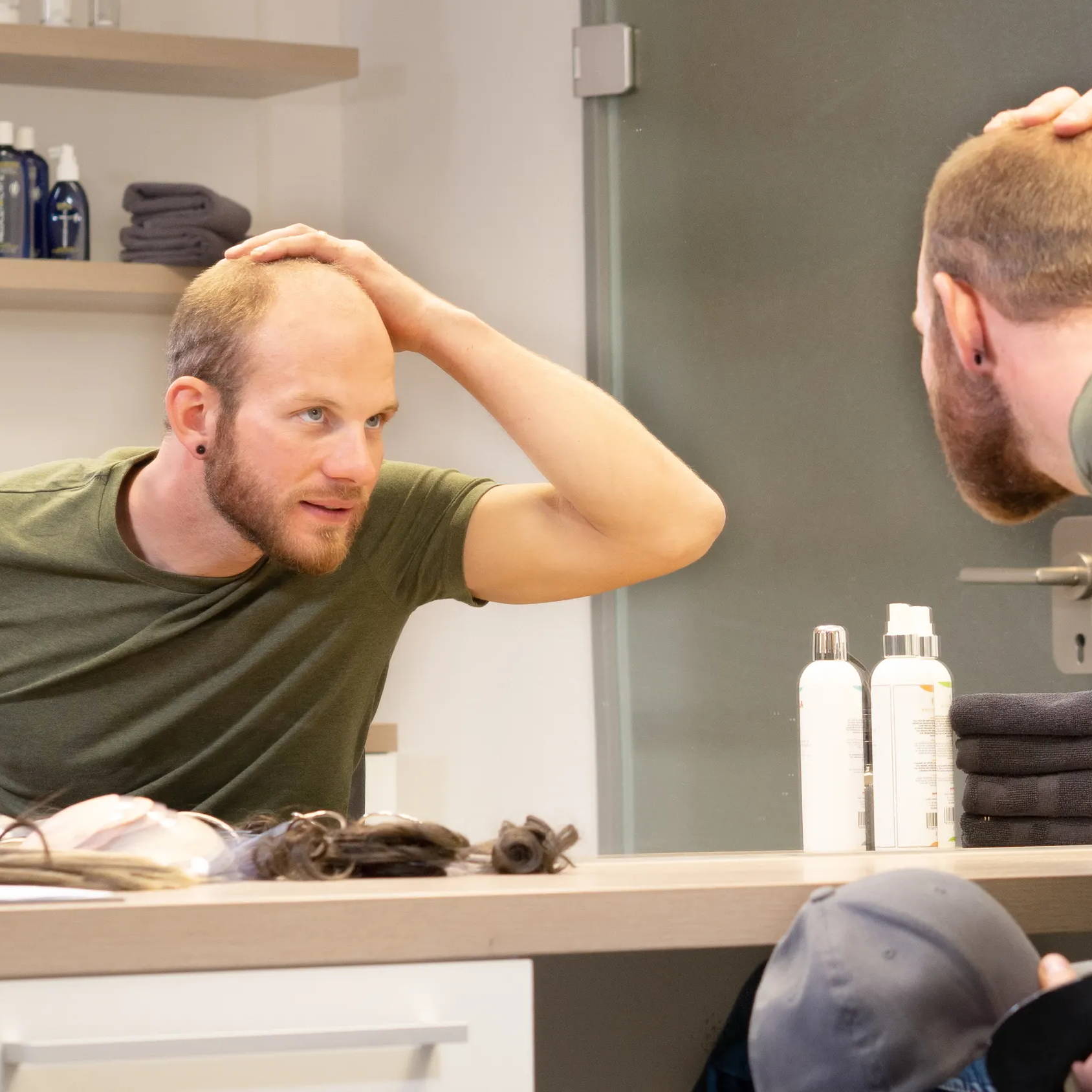 Mann untersucht Haaransatz im Zweithaarstudio