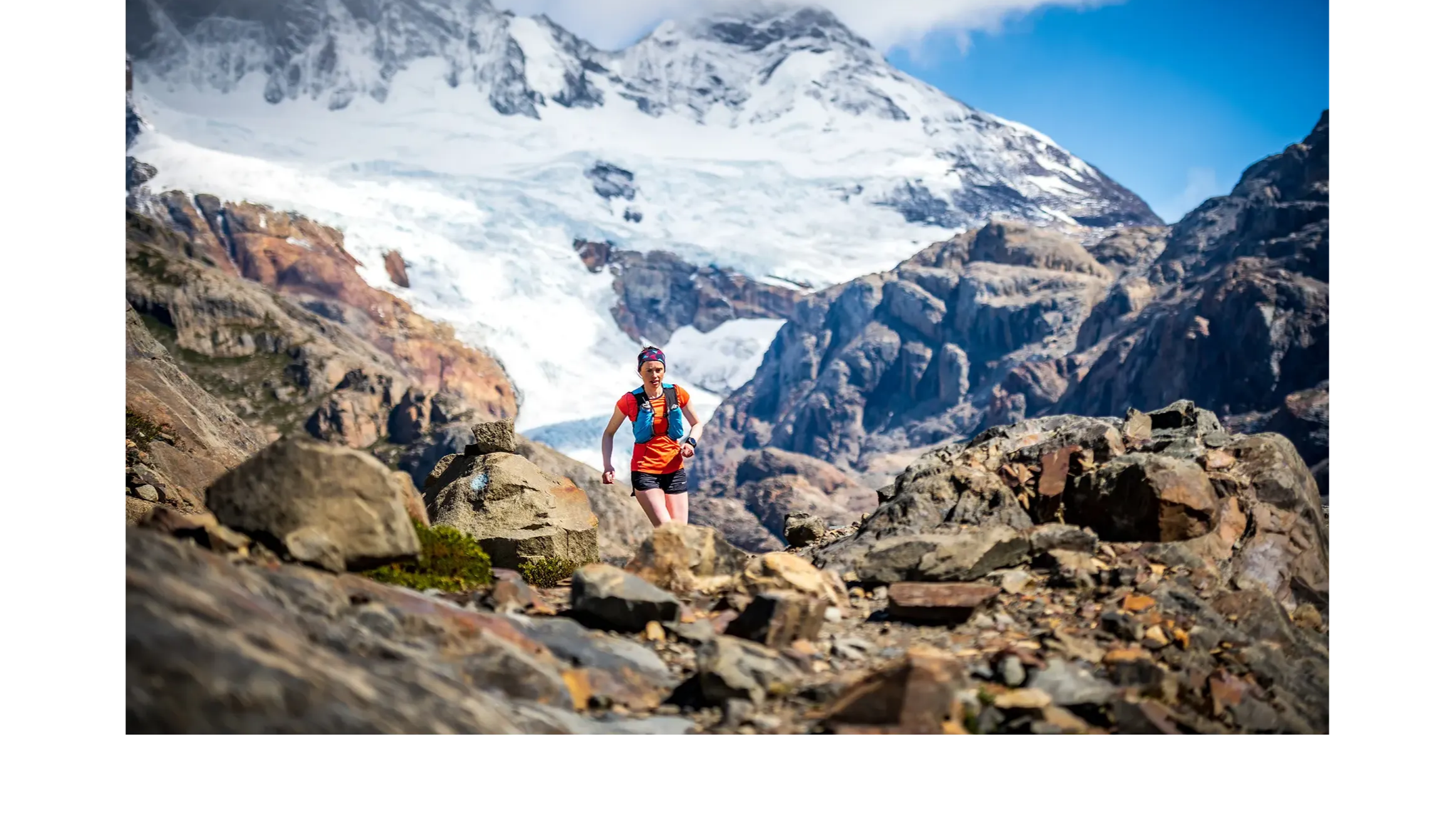 Woman running in mountain backcountry with a Garmin Enduro 2 multisport GPS watch