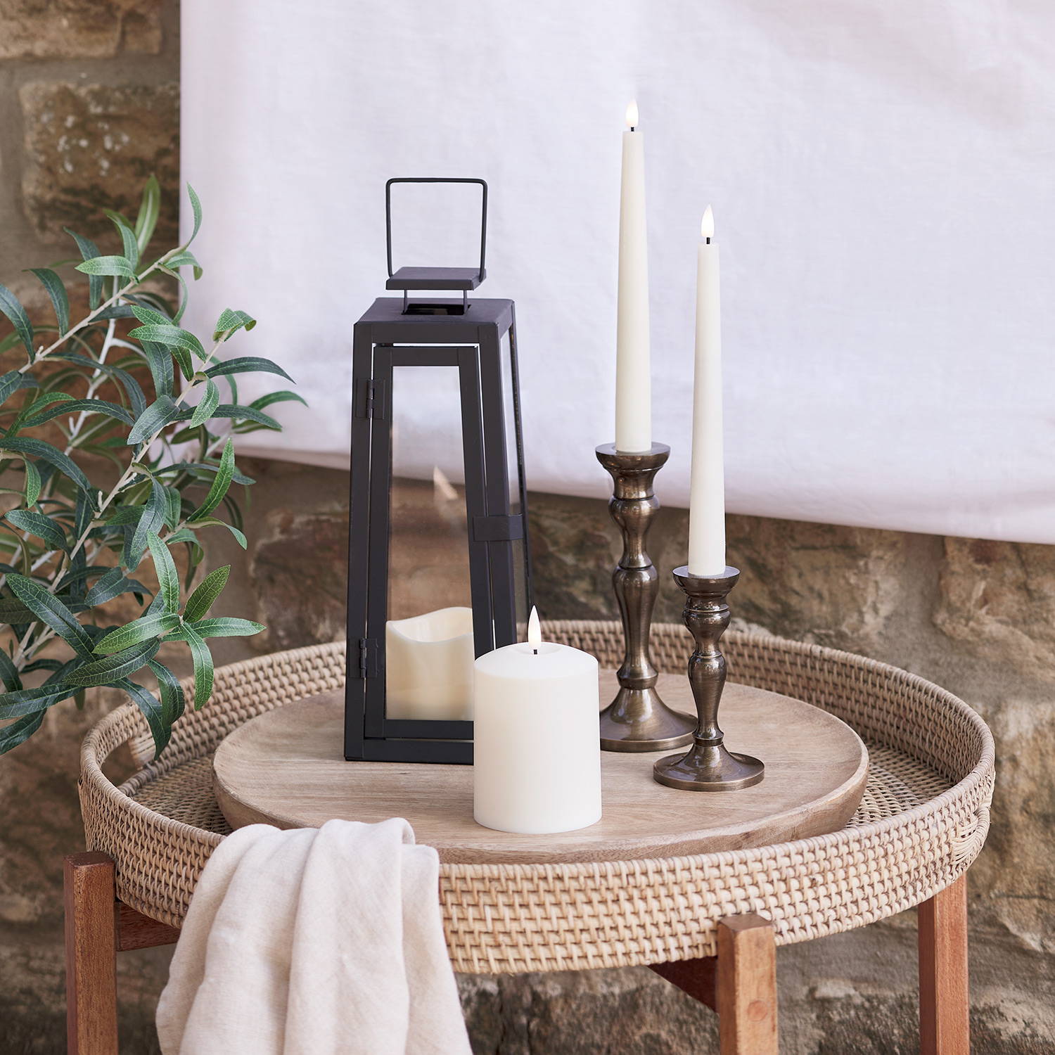 A side table with LED candles in an outdoor summer setting.