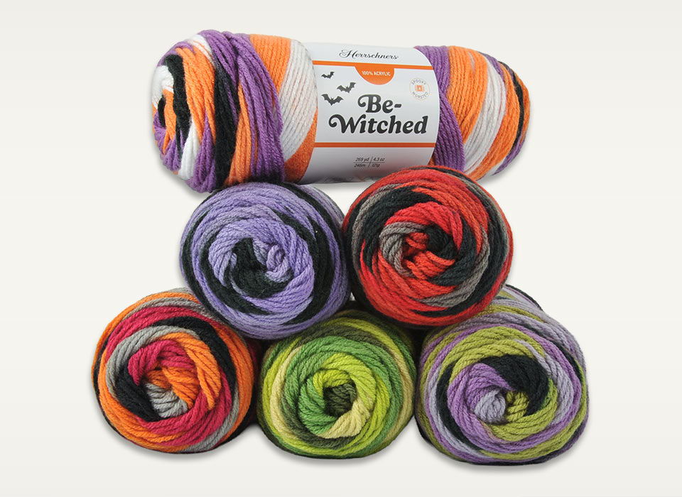 Colorful yarn skeins in Halloween-themed colors stacked together.