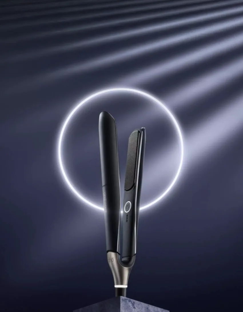 A sleek hair styling tool with a glowing circular backdrop.