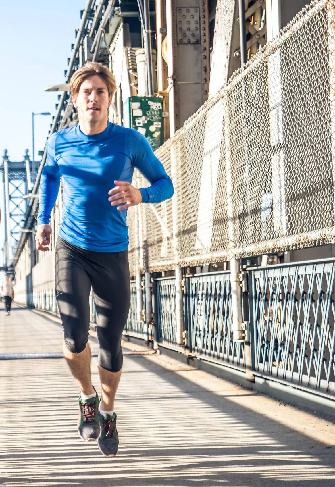 person running on bridge, wearing compression