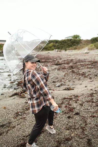 Jr Designer Hanna poses with an umbrella on the beach.