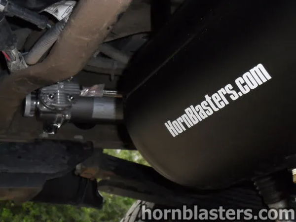 Close-up of the compressor mounted beside the black air tank under Dean's 2005 Chevy Silverado 2500 HD, install photo 7