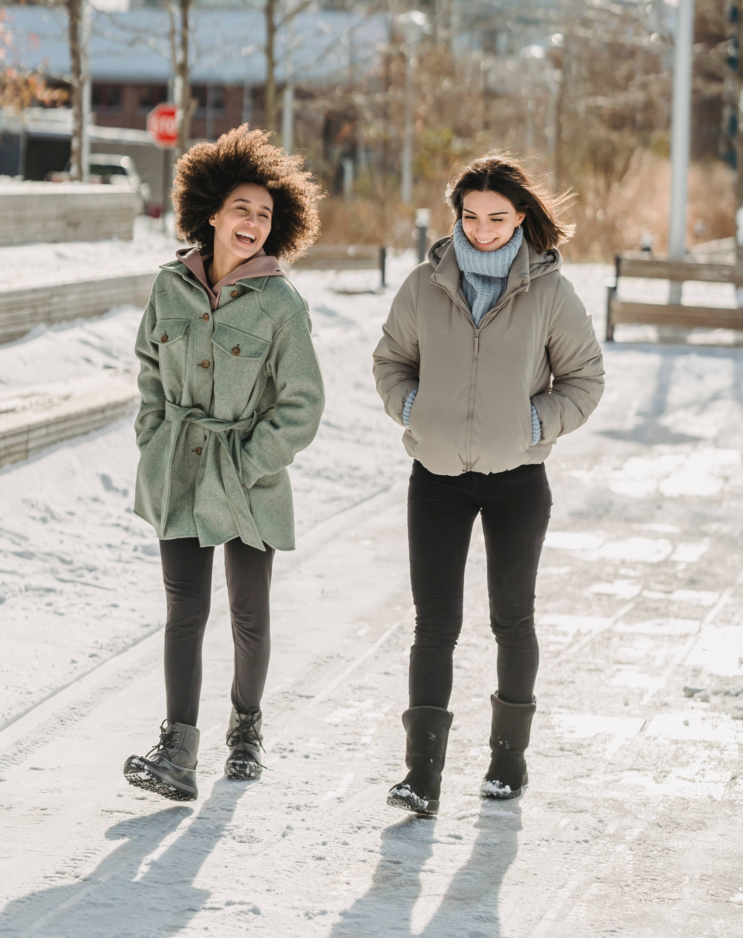 Friends laughing and chatting while on a walk on a sunny winter day