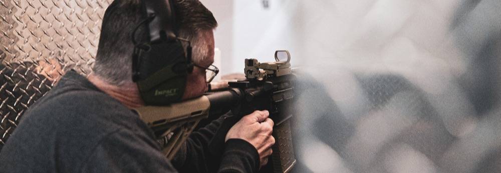 Man shooting AR15 with red dot optic