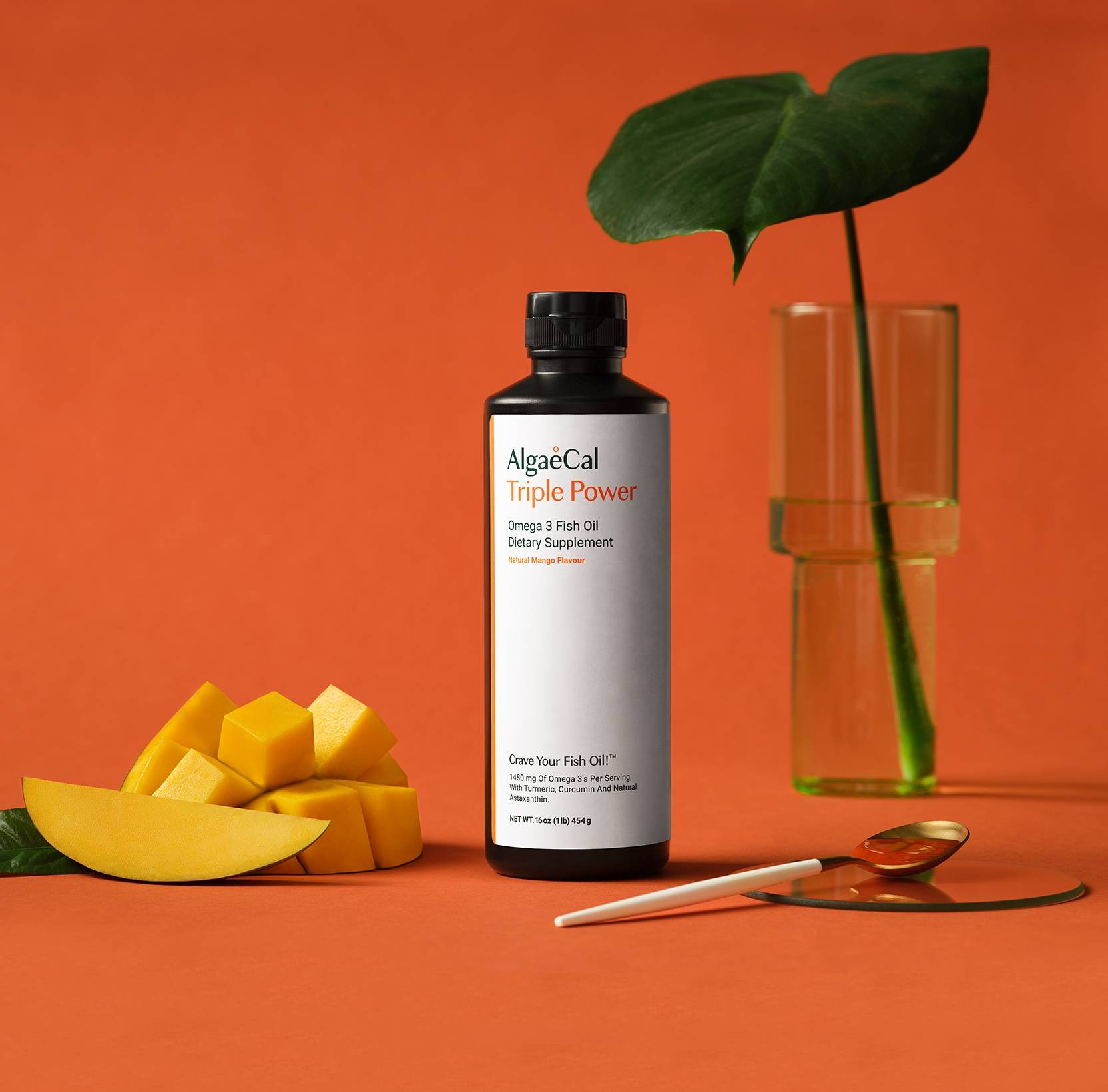 A mango beside a bottle of Triple Power Fish Oil
