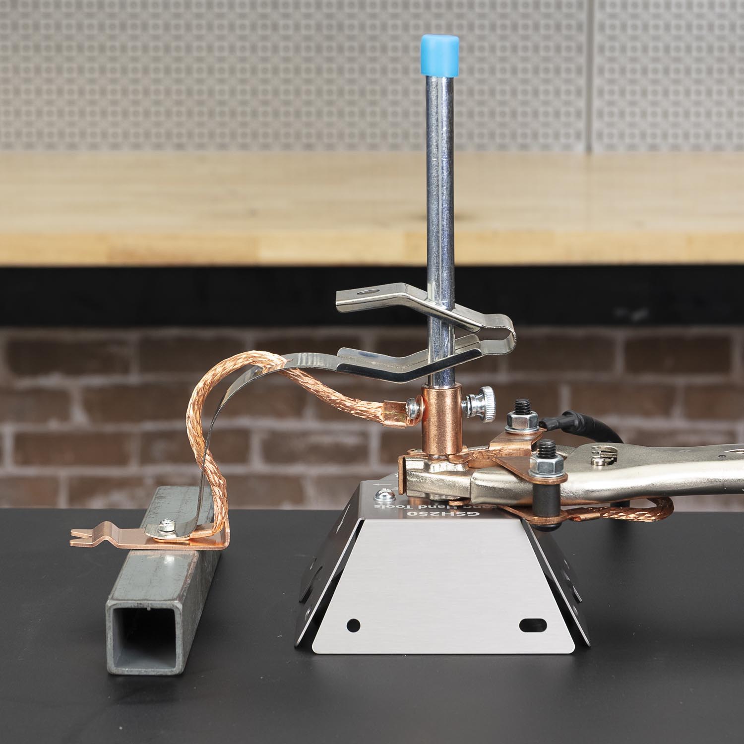 Tool setup on a workbench with metal components and copper wiring.