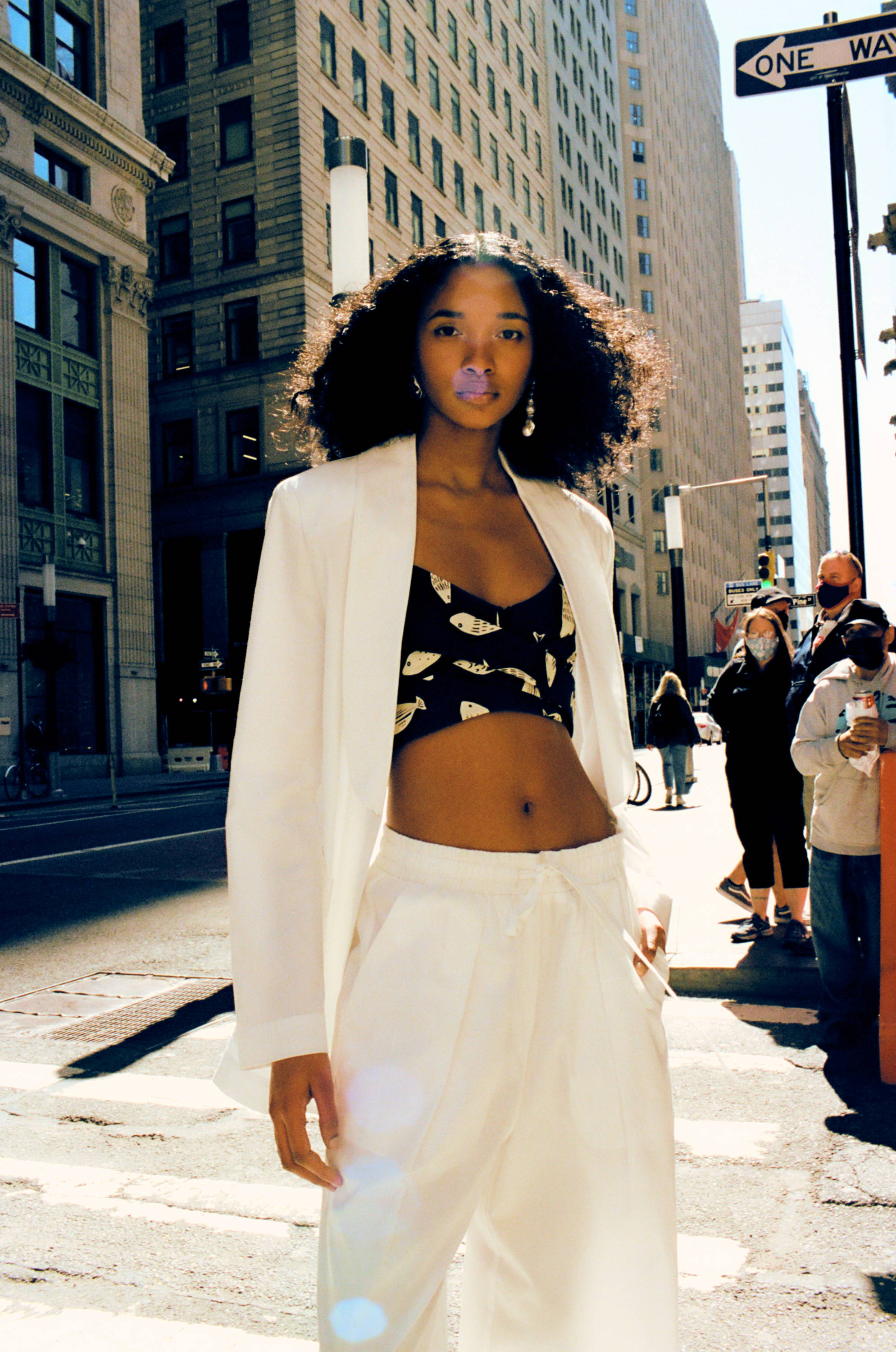 Person in stylish outfit walking on a city street.