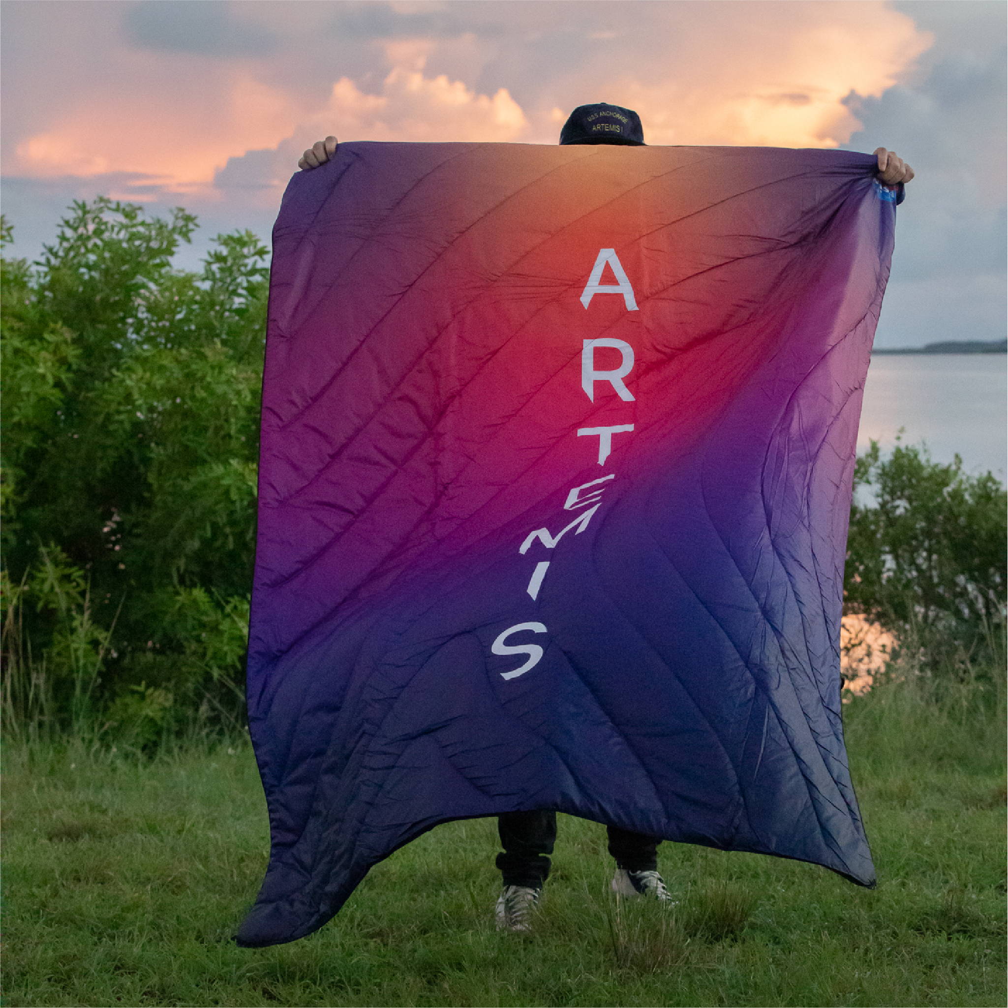 Man holding a NASA Artemis Rumpl purple blanket