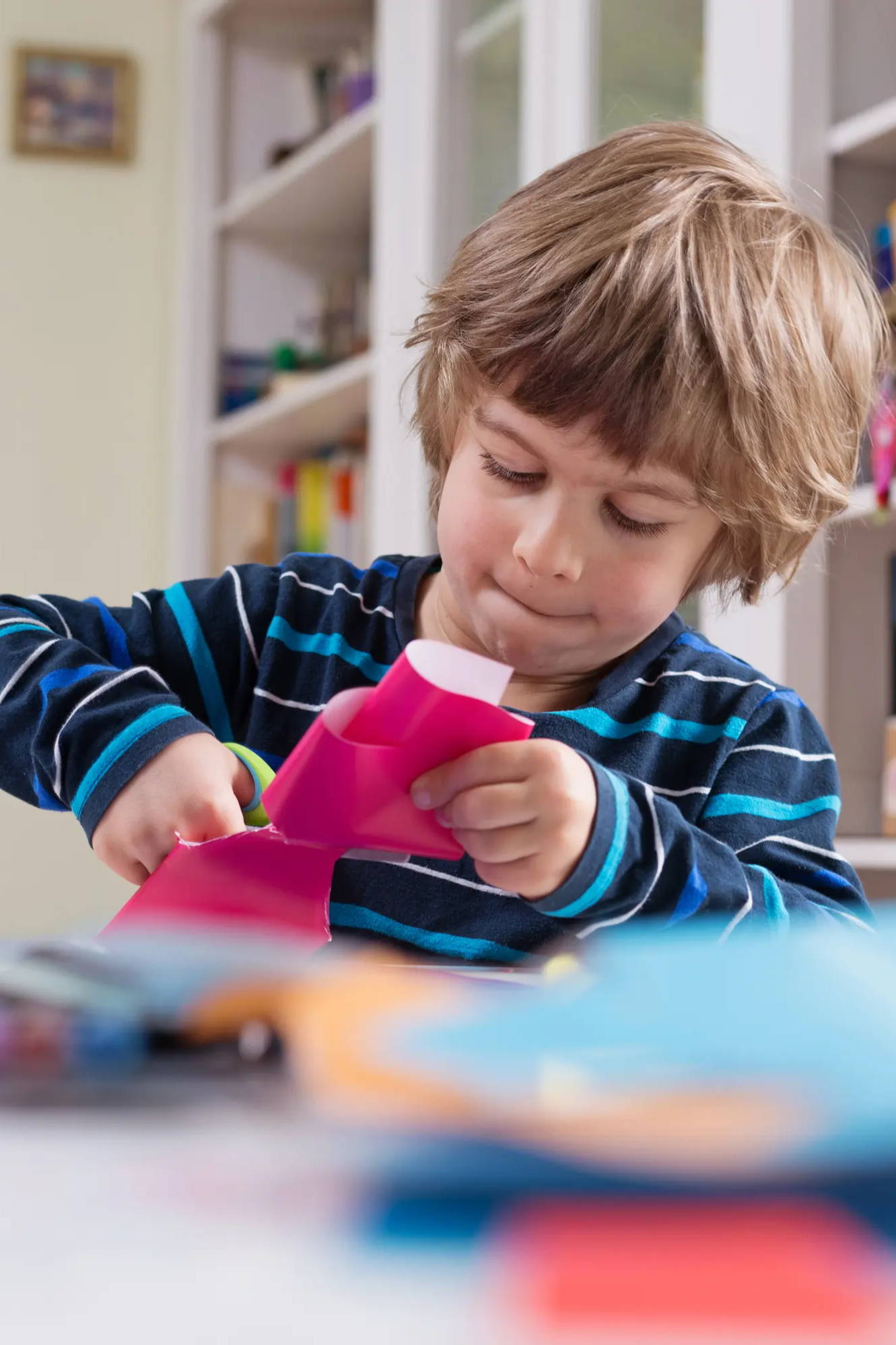 Kid at school cutting paper