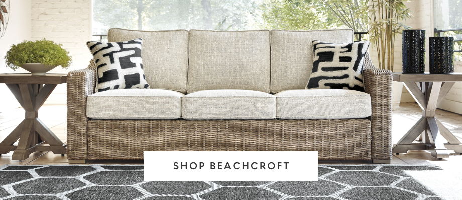 A stylish sofa with decorative pillows and a geometric rug.