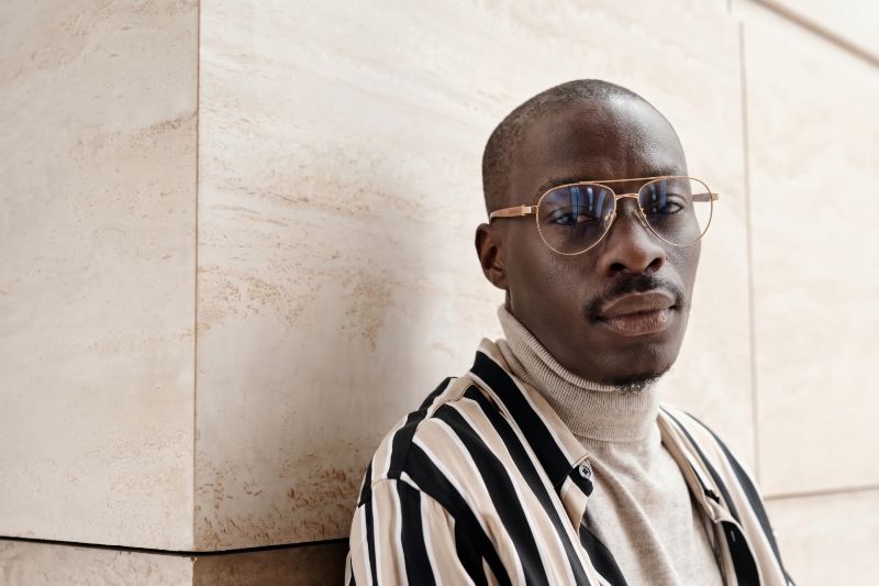 Bald man wearing Purpose Gold teardrop aviator glasses