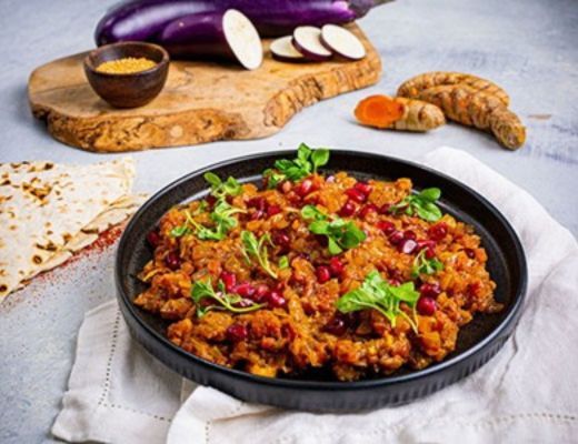 A plate of colorful vegetarian dish with herbs, accompanied by ingredients.