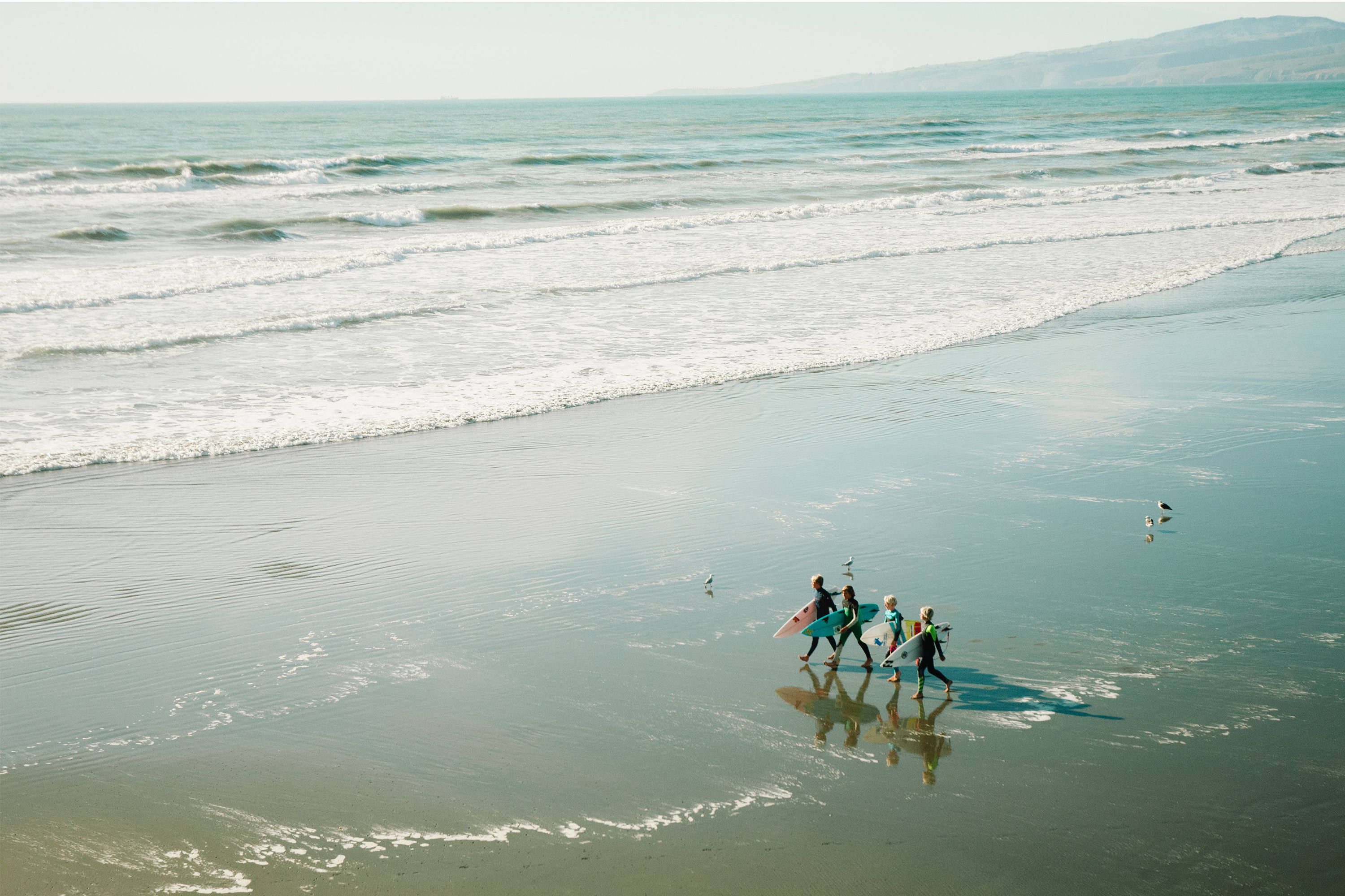 surfers walking on the beach