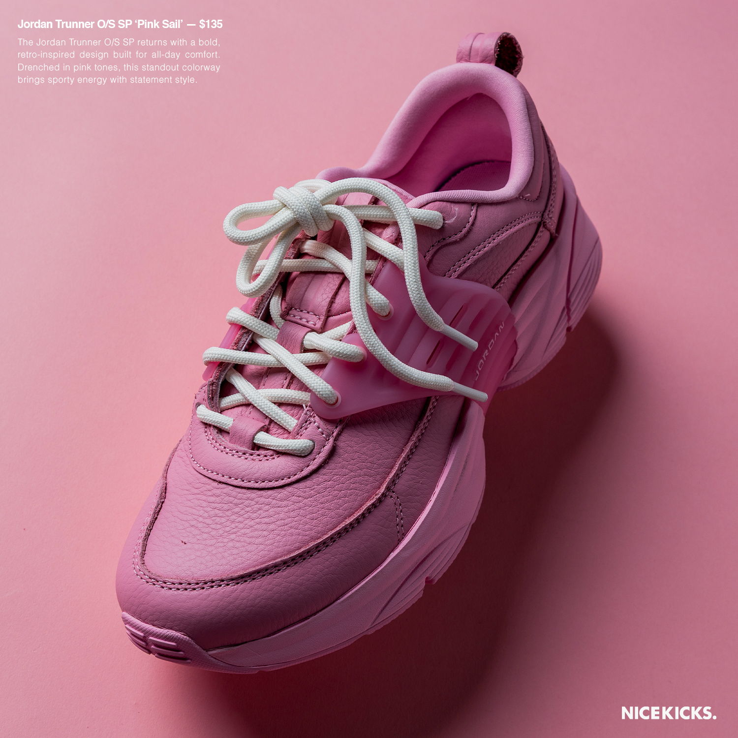Pink athletic shoe with white laces on a pink background.