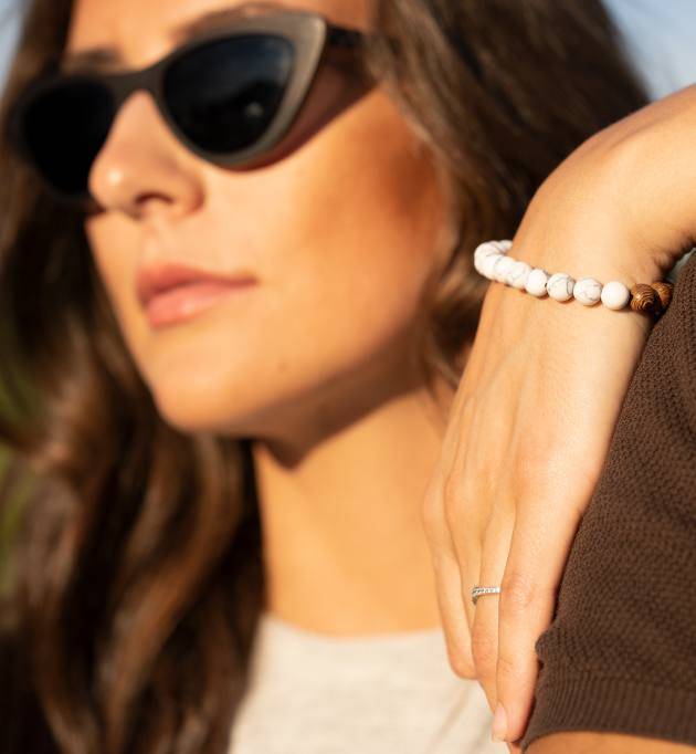 Woman wearing oak wood and marble bead bracelet and Selena, Ebony wood polarized sunglasses