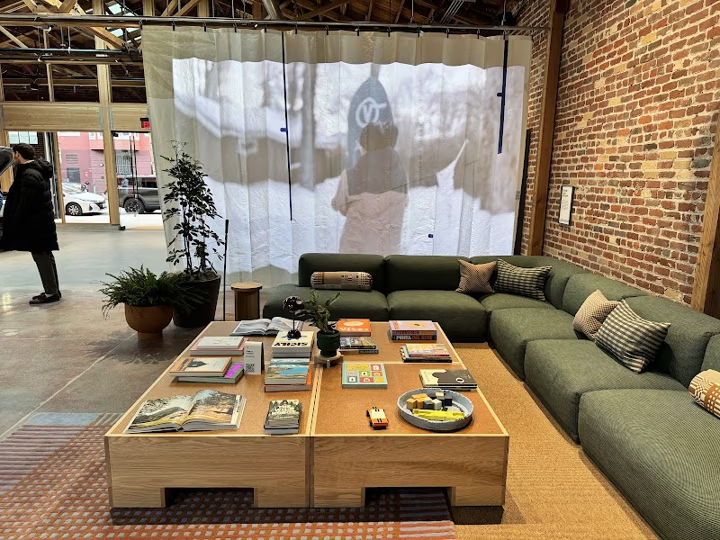 Cozy lounge area with a green sofa and coffee table displaying magazines.