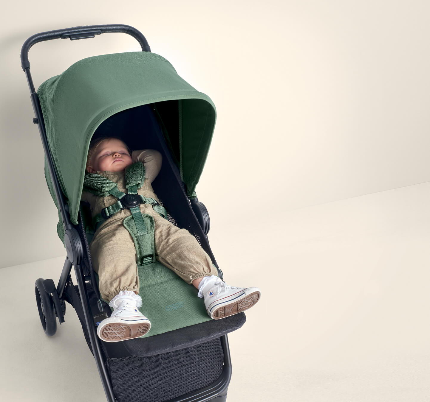 Child resting in a Libro Bay Green stroller with a large canopy.