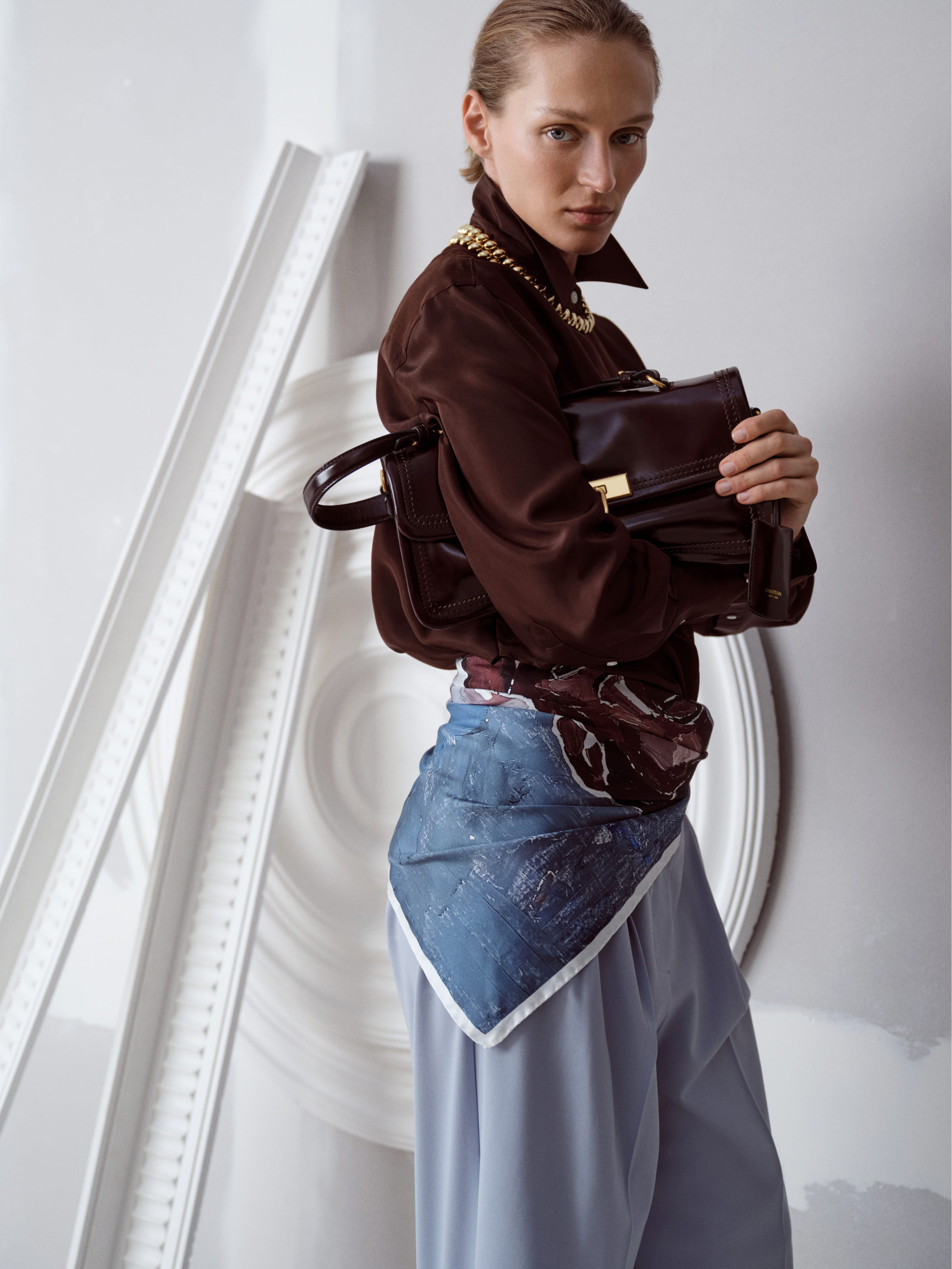Model posing in stylish outfit against a minimalist background.