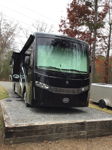 Front three-quarter Chuck's black 2019 Thor Motor Coach Palazzo RV with FMCA emblem parked on gravel pad photo 1