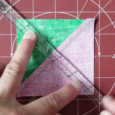 Using a quarter inch ruler on a half square triangle block