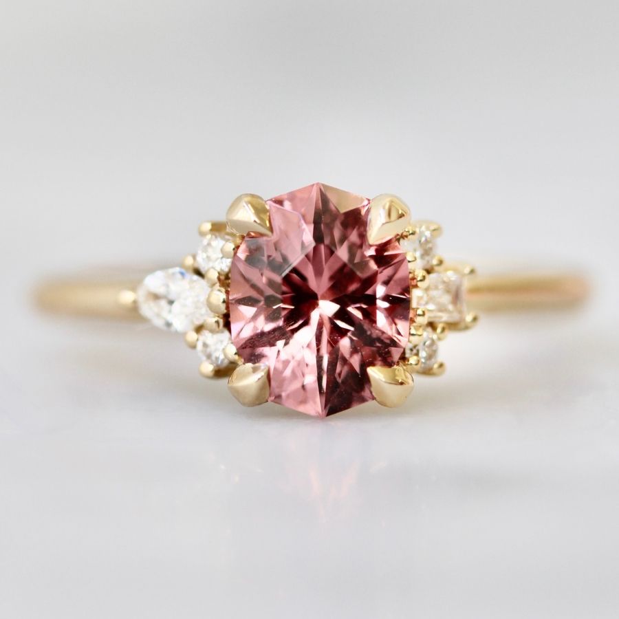 Oval cut pink garnet ring with half halo of diamonds