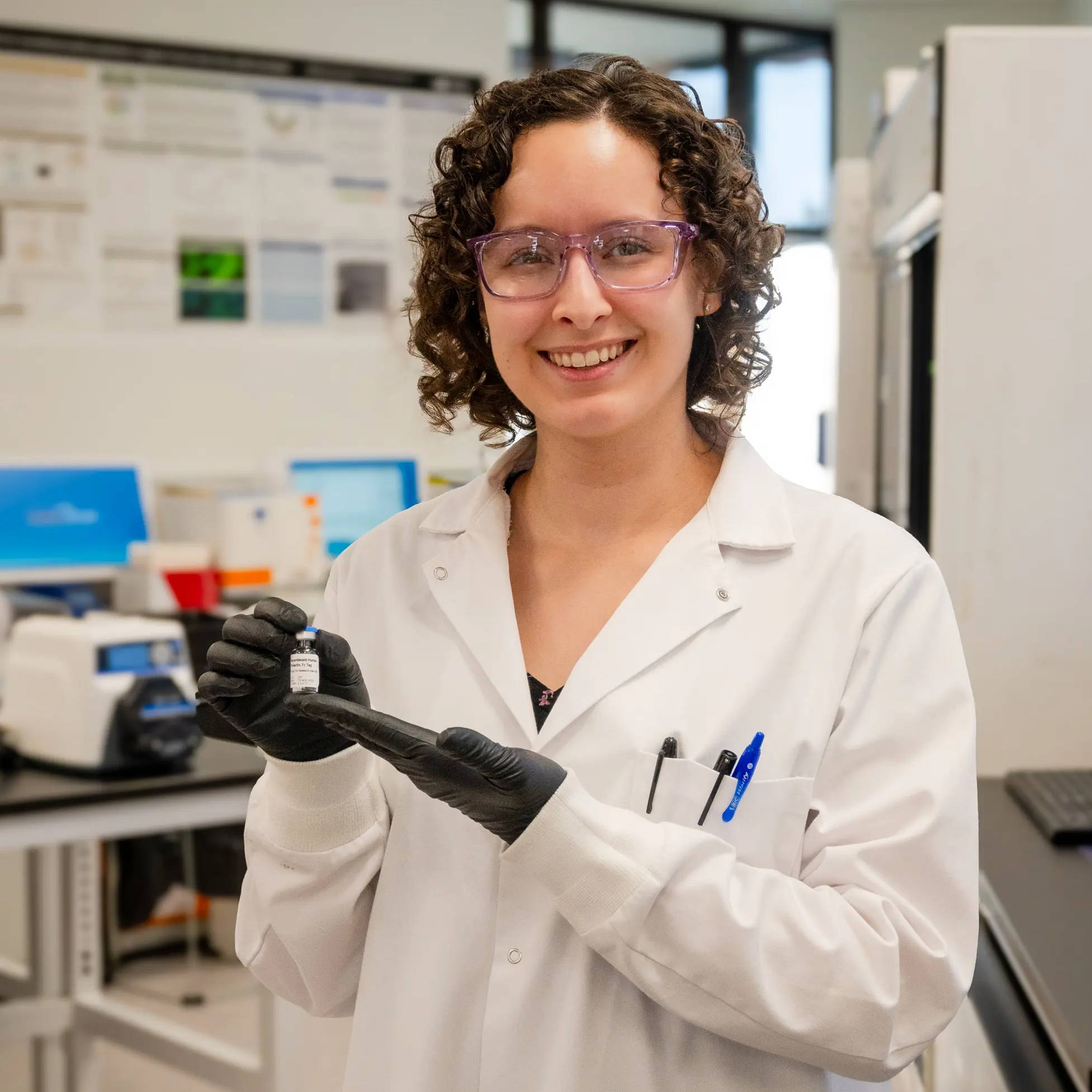 Women in STEM - Future Fields Senior Research Scientist Paige holding a vial of recombinant human prolactin, Fc tag