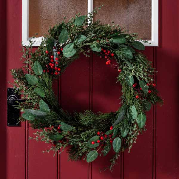 Red berry Christmas wreath on a red door.
