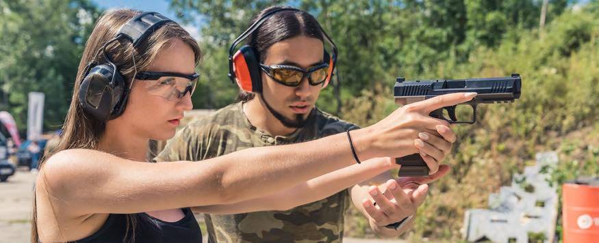 Woman being trained on using a handgun