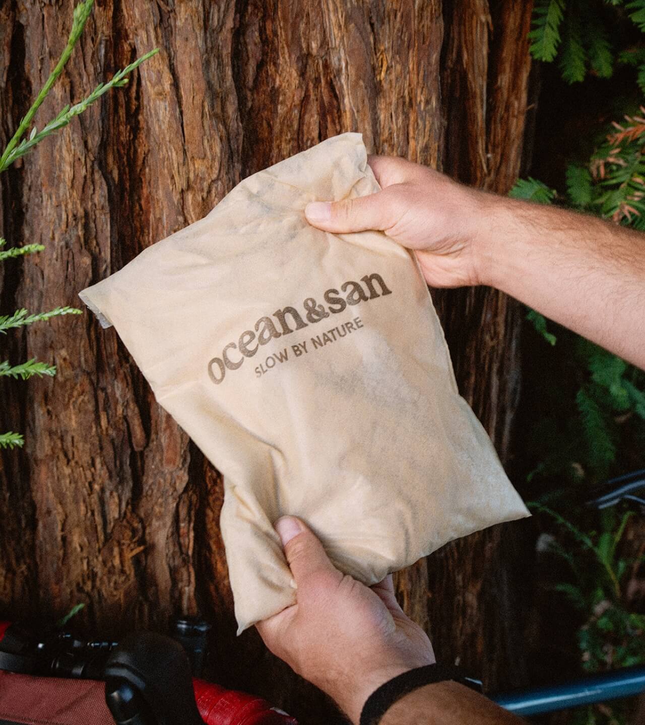 Person holding a beige bag labeled 