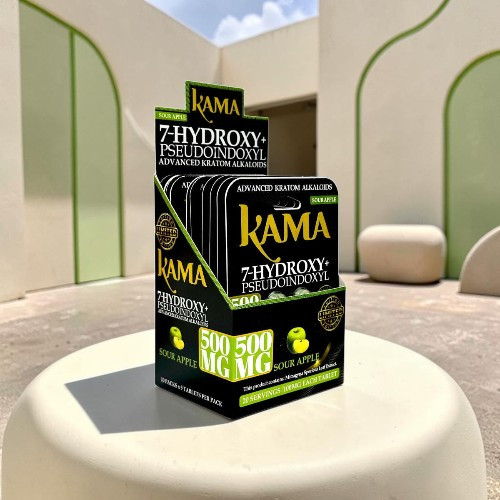 Boxes of Kama products on a table against a modern architectural background.