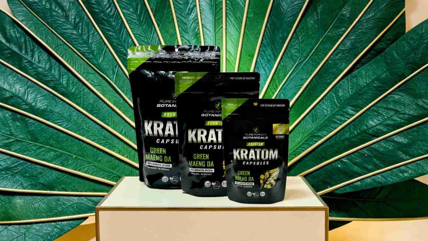 Three bags of Kratom products displayed against a green leaf background.