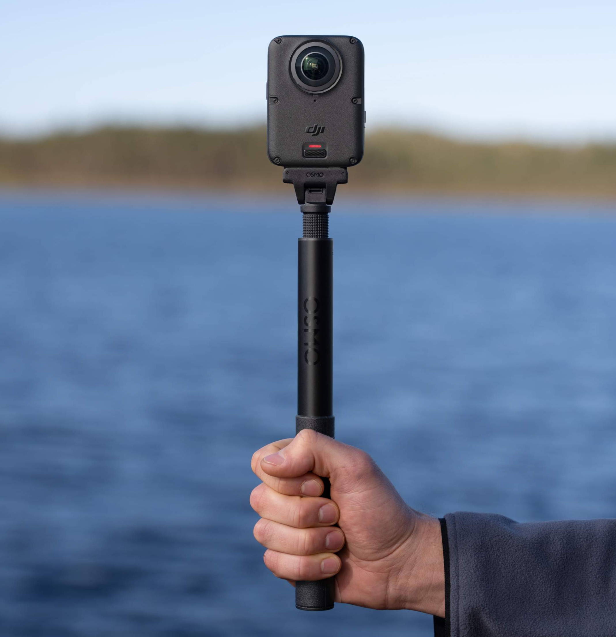 Osmo 360 II attached to a selfie stick held by a hand