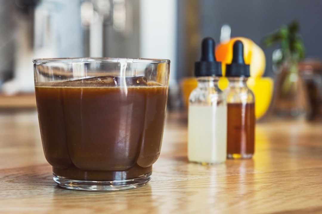 clear glass coffee cup on brown wooden surface