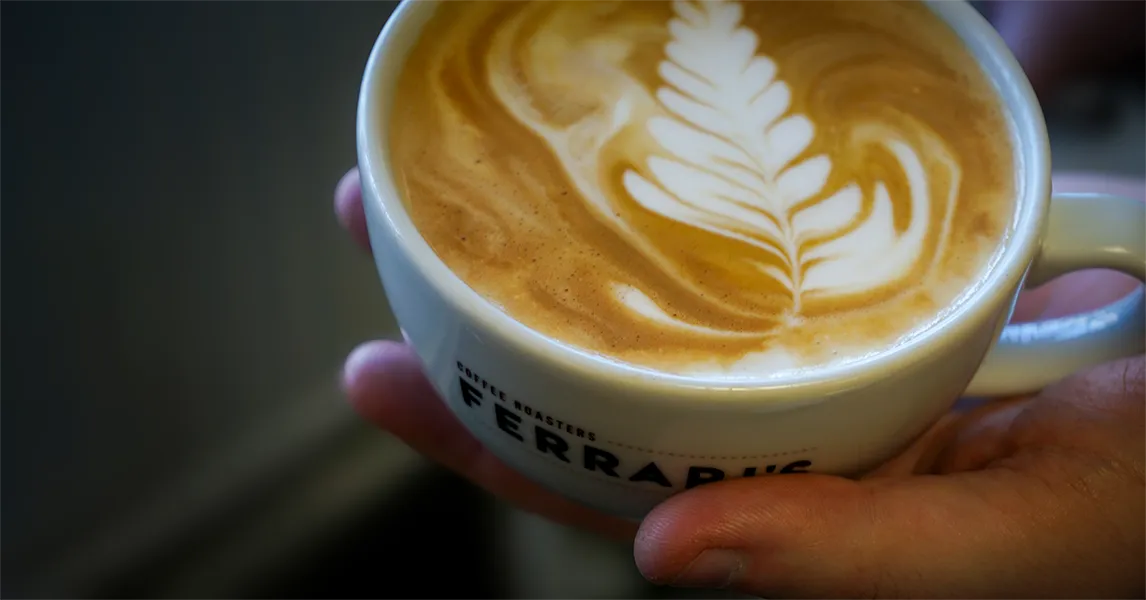 Ferrari's Coffee, a hand-holding Ferrari's Cup with latte art