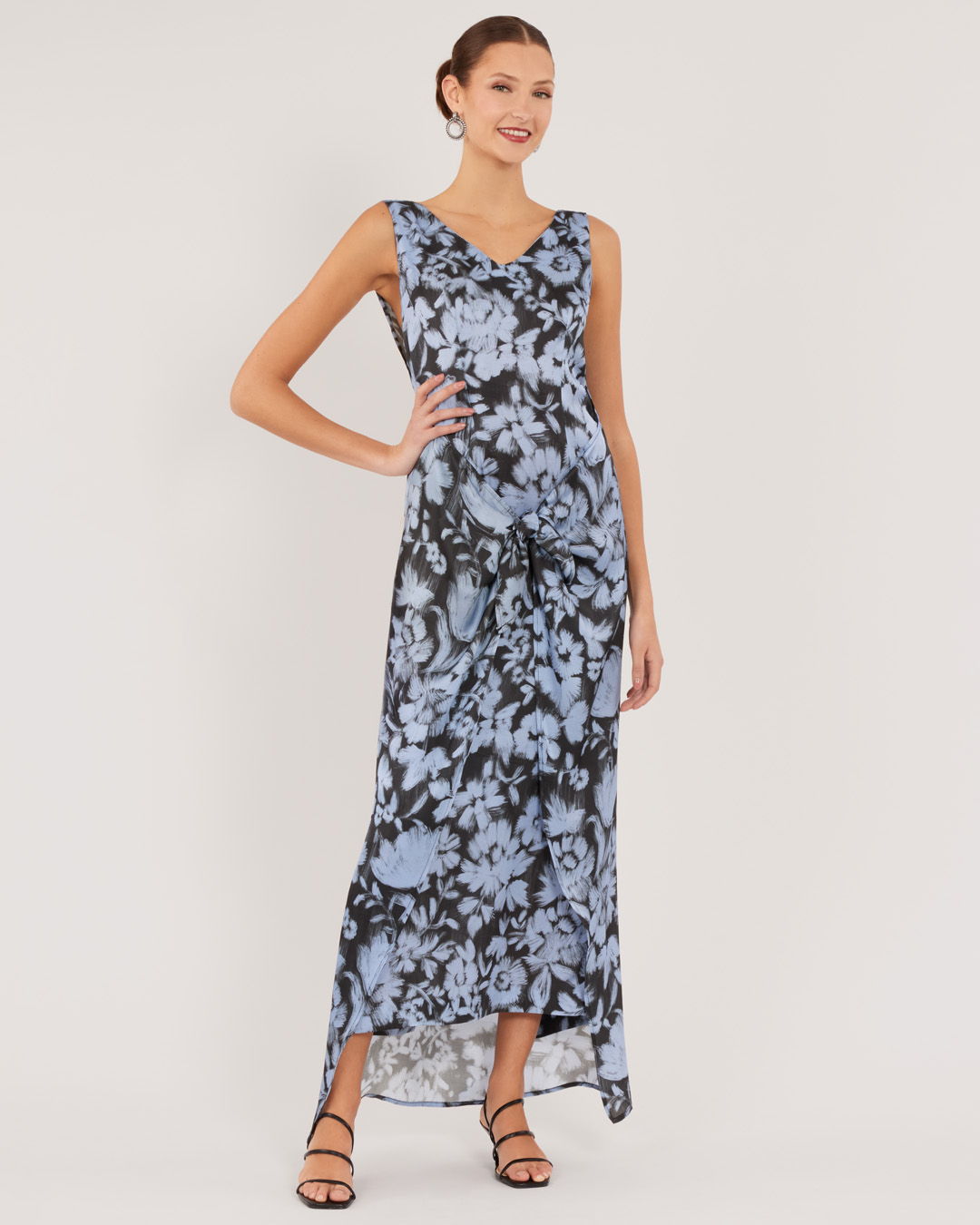 Woman in a floral blue maxi dress with strappy sandals.