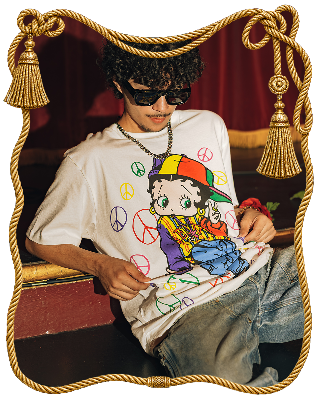 Person wearing a colorful graphic t-shirt with peace signs, sitting indoors.