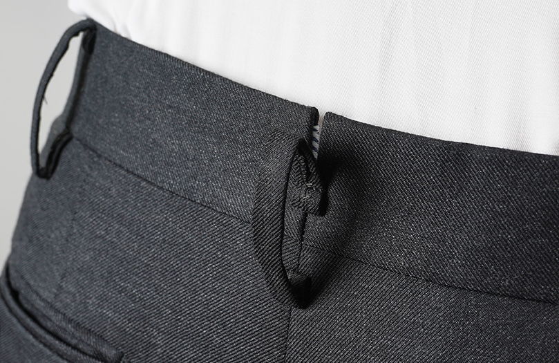 Close-up of gray pants with zipper and waistband detail.