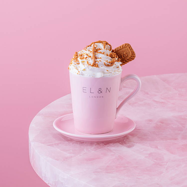 Lotus Biscoff hot chocolate with whipped cream on pink table 