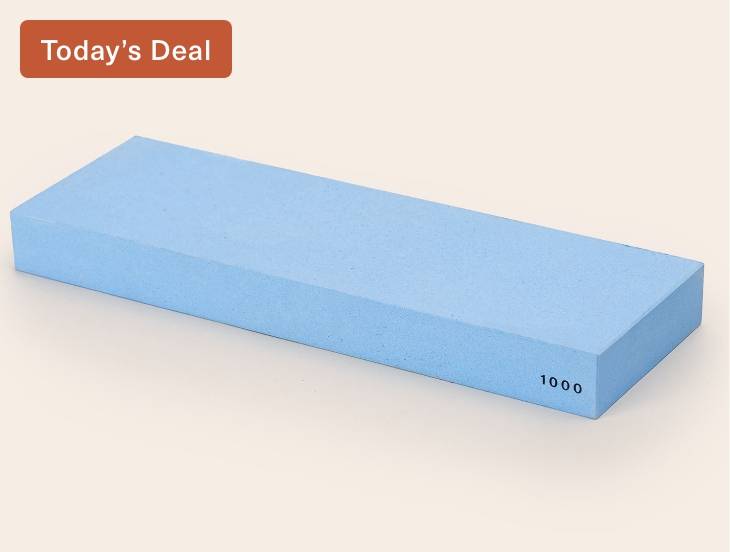 A blue Misen 1000-grit Sharpening Stone, seen from an angle with the number 1000 visible along the edge.