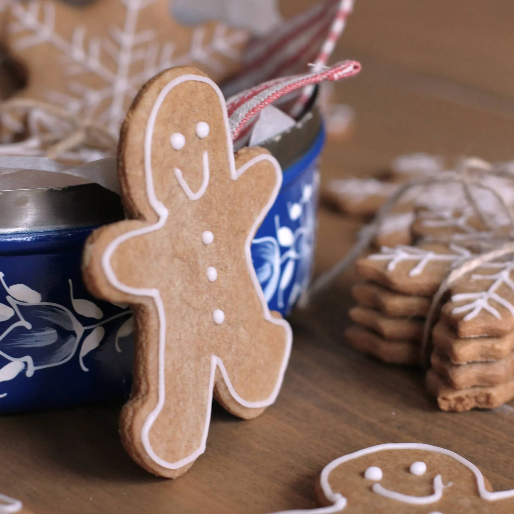 A gingerbread man stood against a biscuit tin