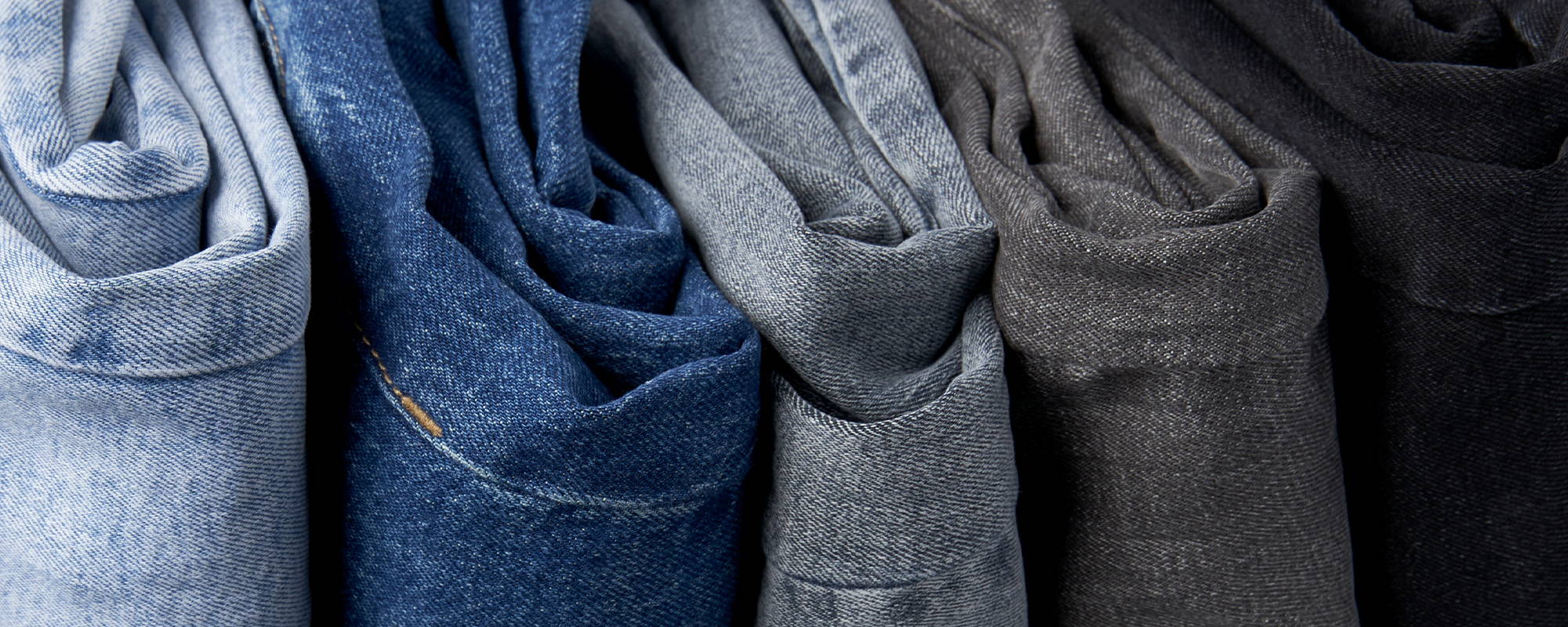 A stack of tall women's jeans in light blue, dark blue, grey and black
