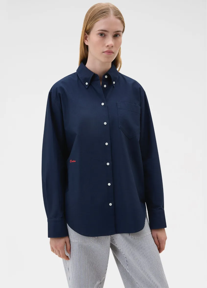 Woman wearing a navy blue button-up shirt.