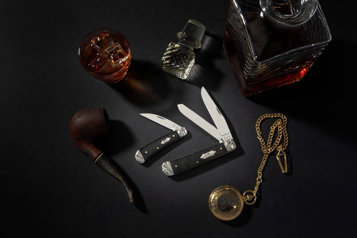 Ebony wood bolster knives surrounded by luxury items.