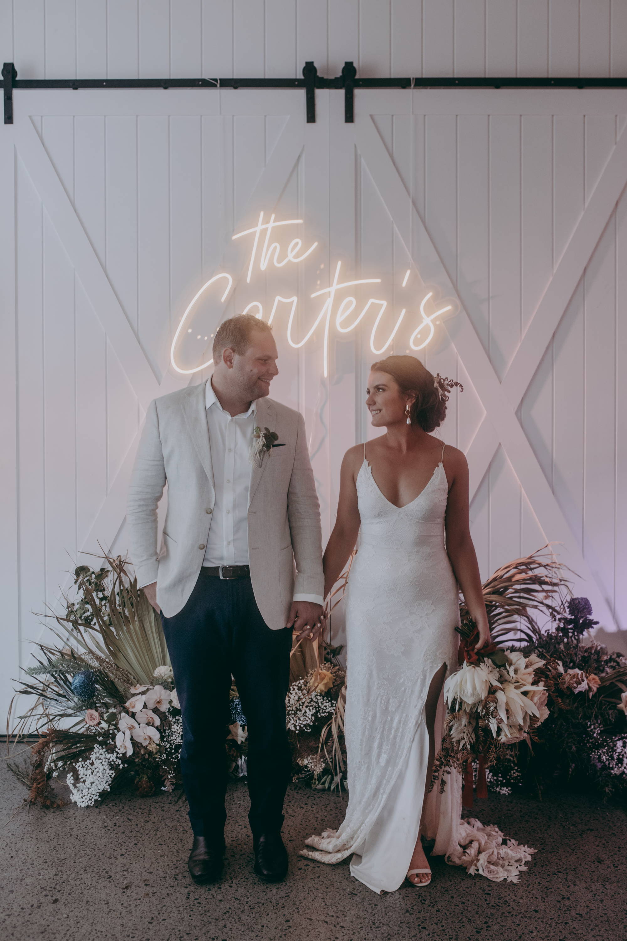 Bride and groom underneath neon lights