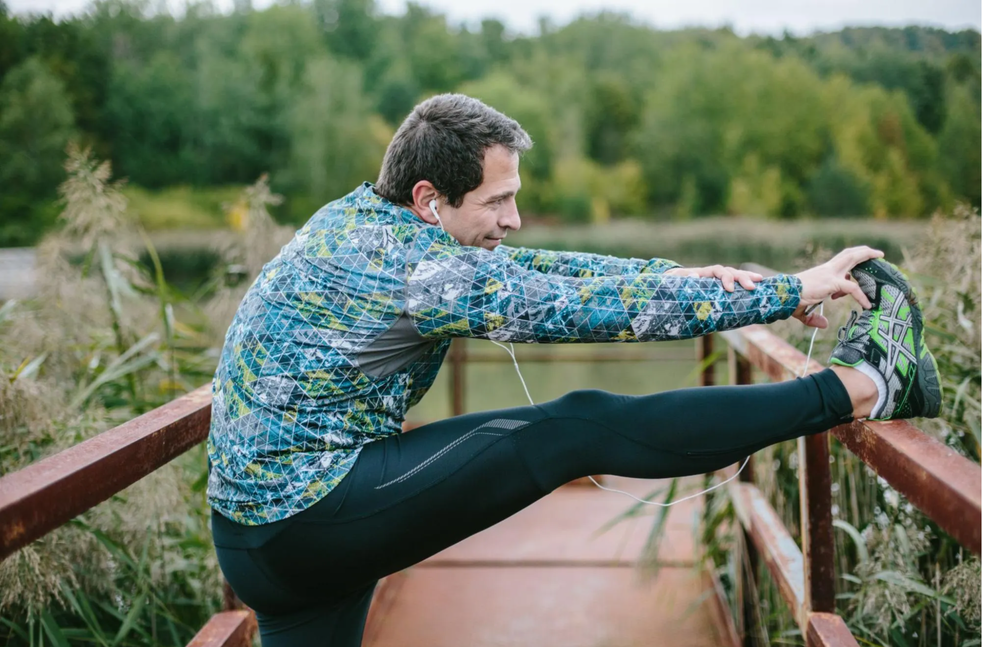 man listening to music and stretching for run